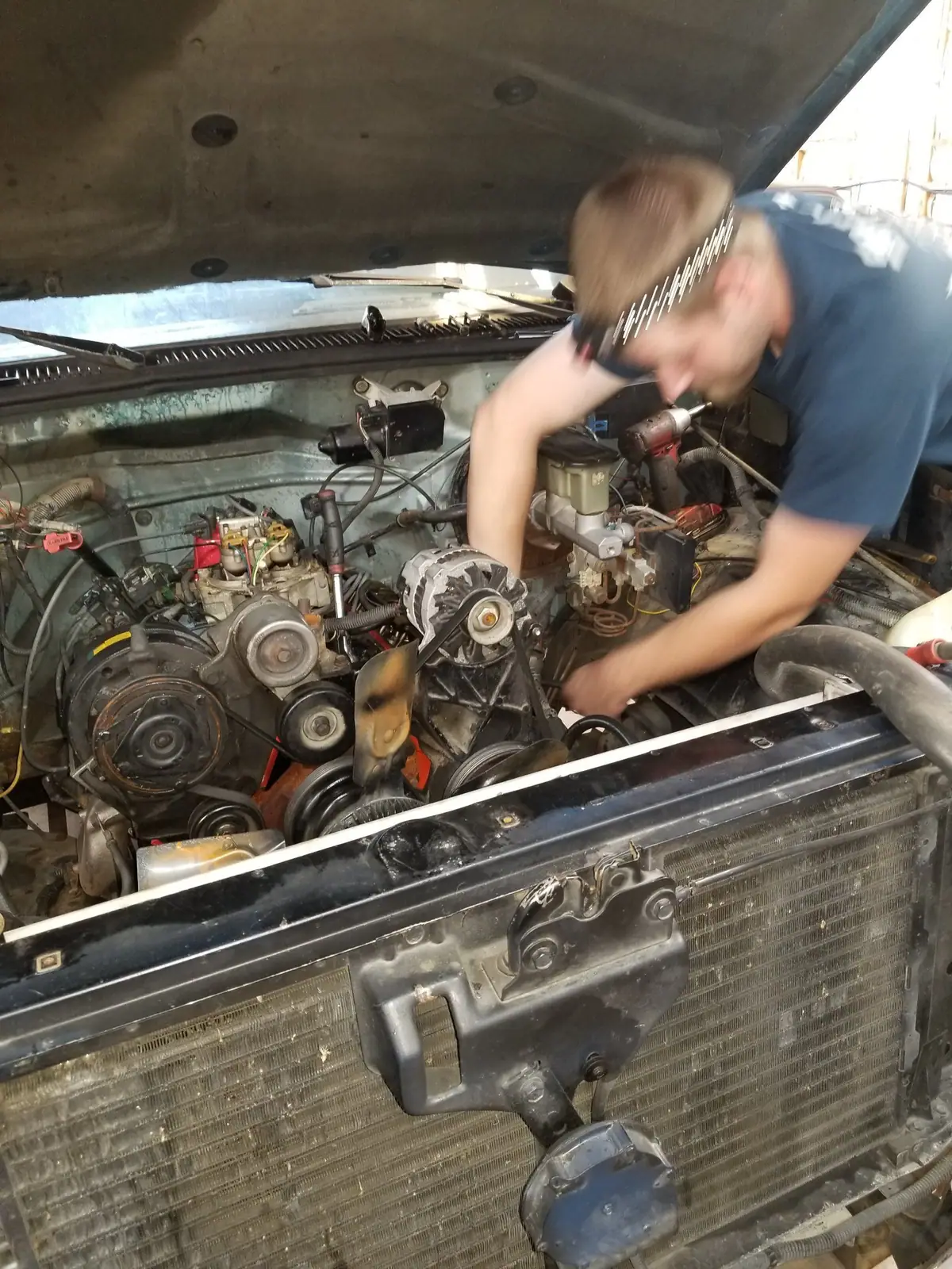 J&W mechanic working under the hood of an older truck