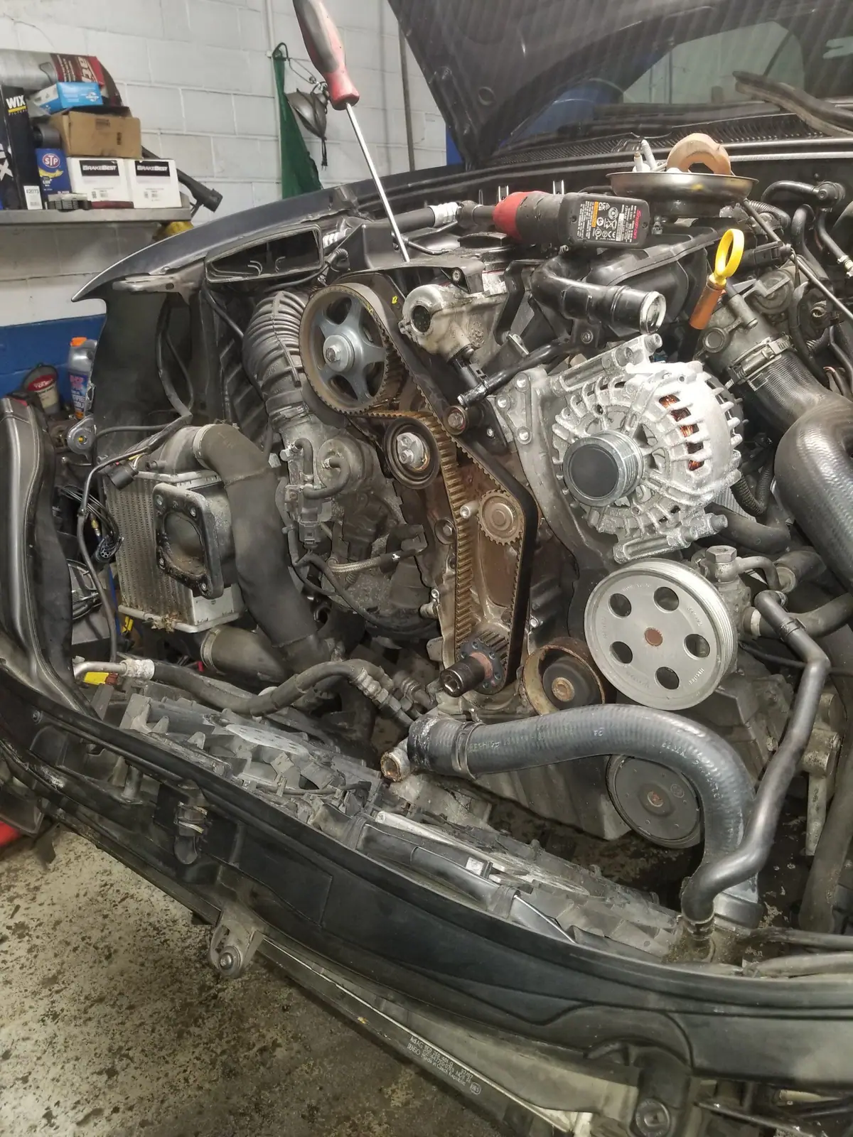 Car with the front bumper and radiator support off and the timing belt exposed