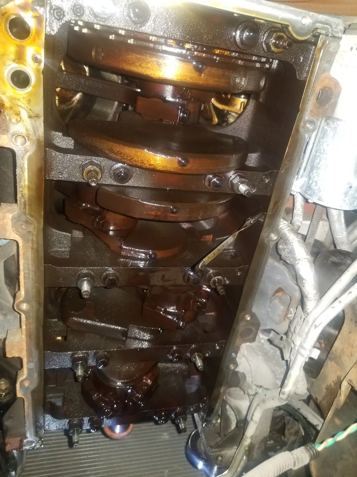 Engine bottom end with the oil pan off and the crankshaft visible