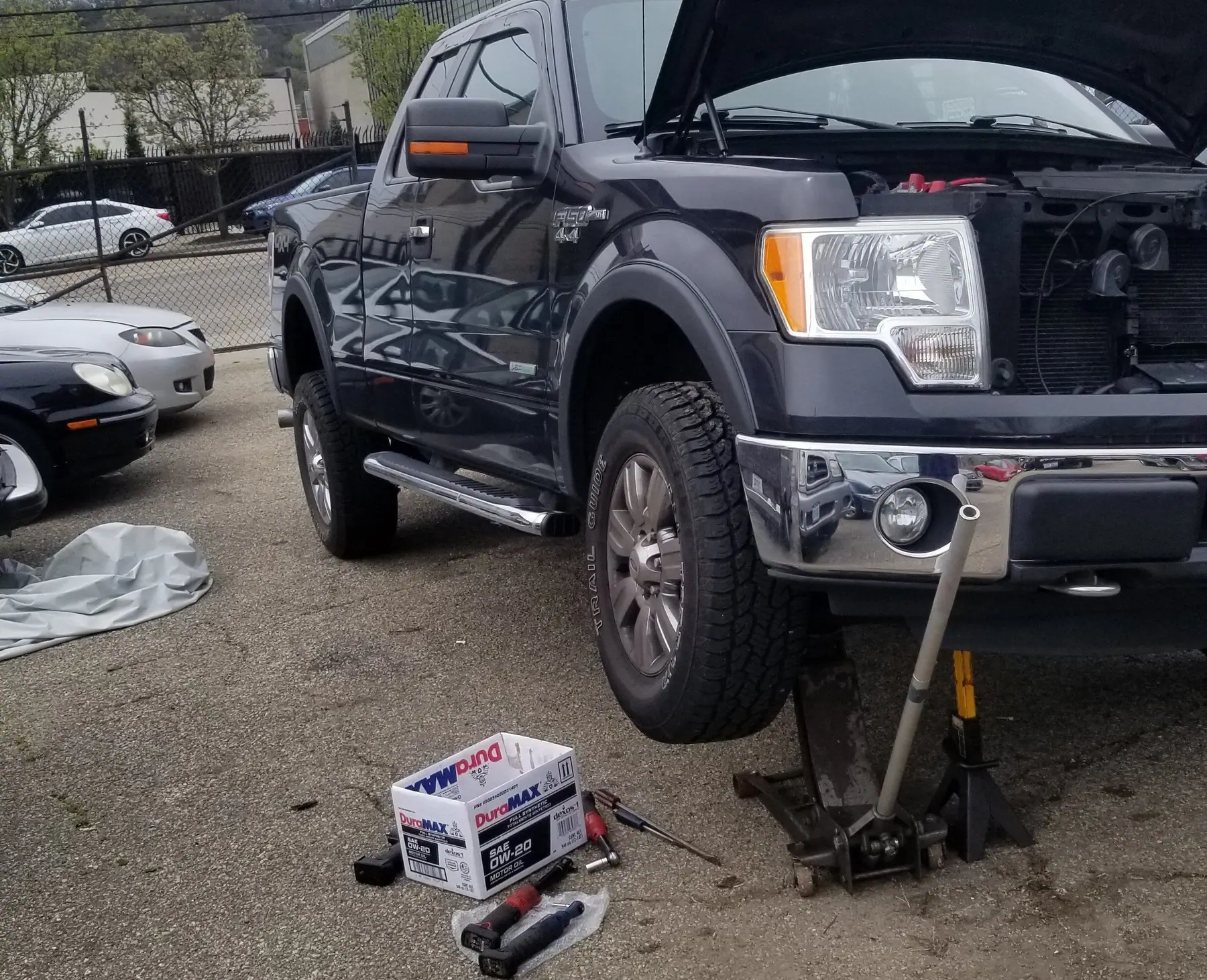 Ford F-150 on a floor jack and stands, hood up