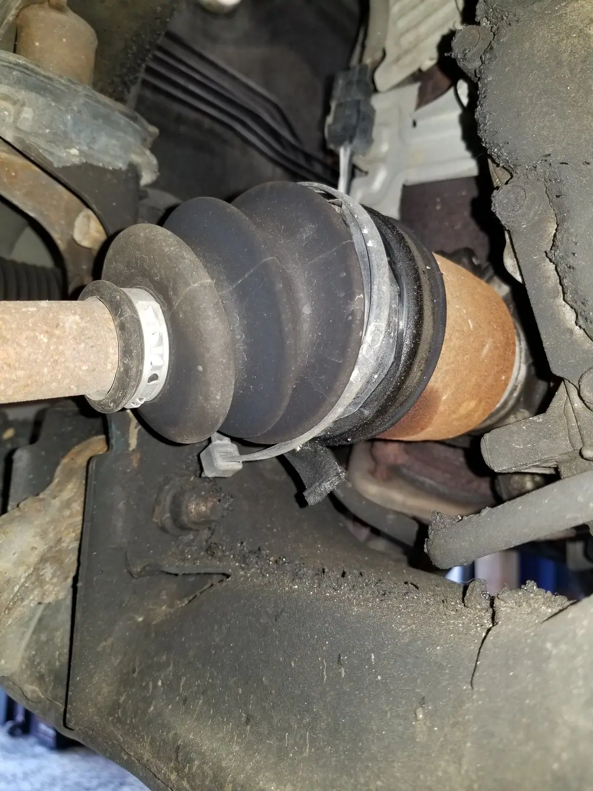 Front CV axle and boot under a vehicle