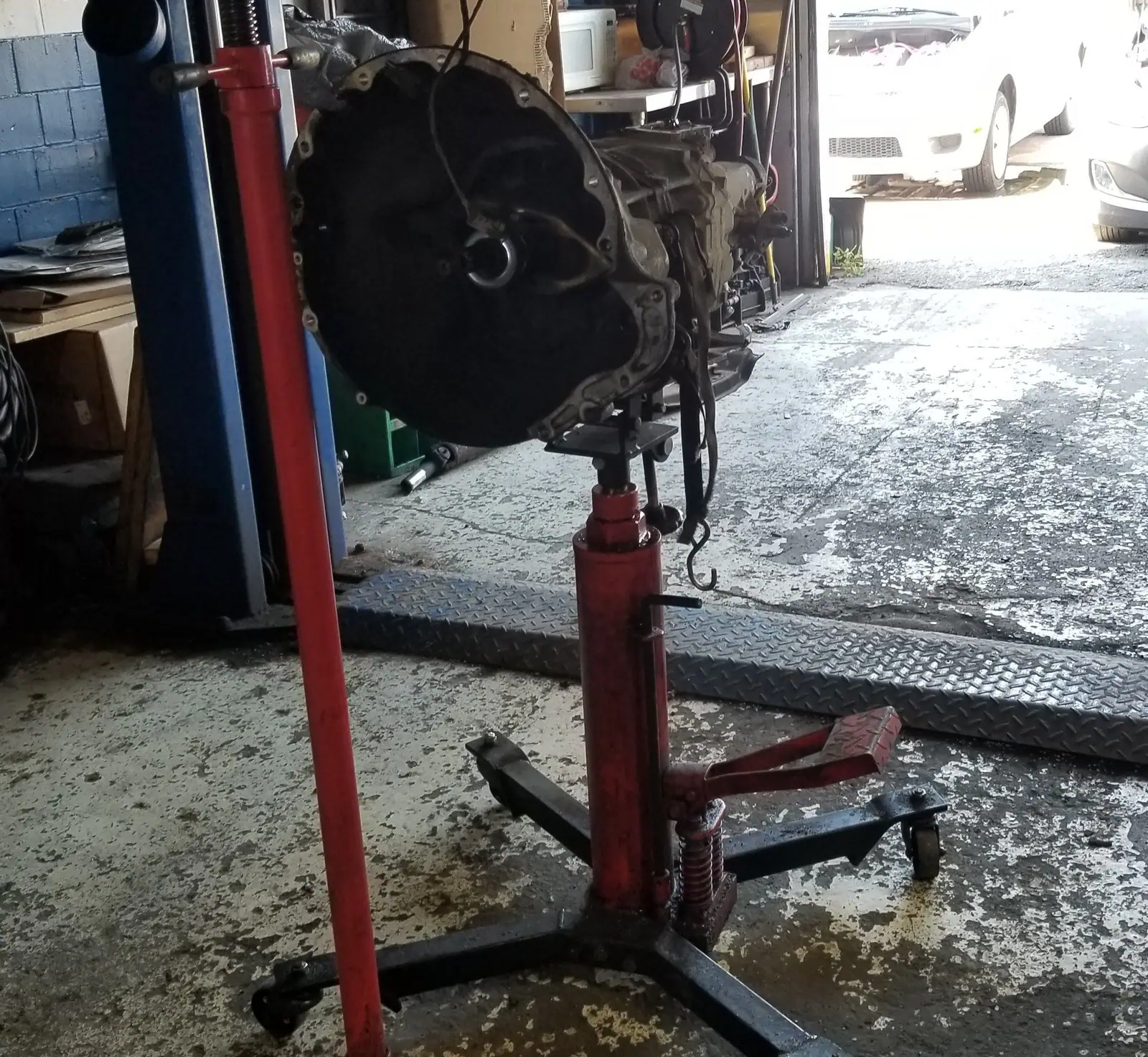 Transmission on a transmission jack beside the open bay door