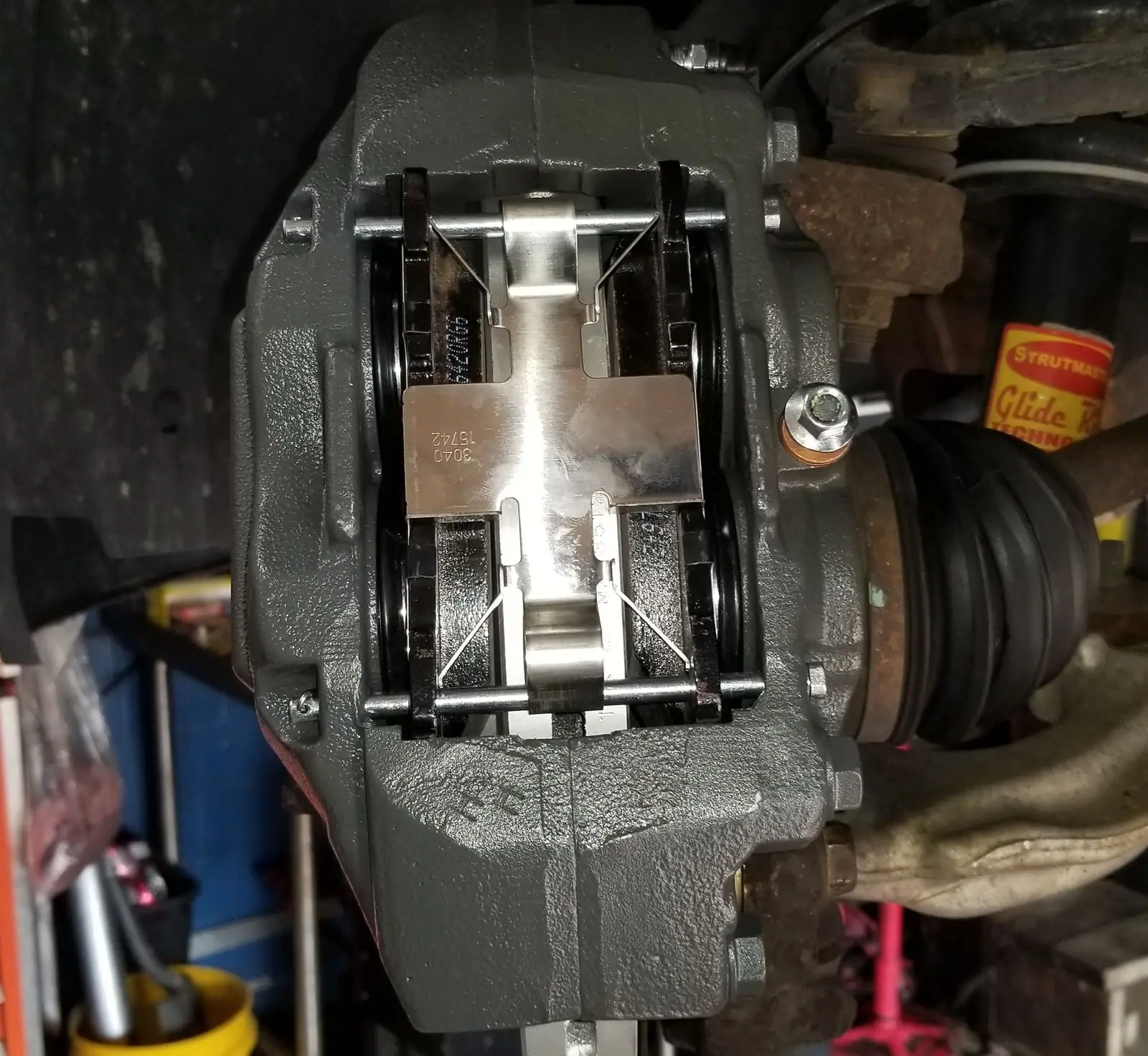 New brake caliper and pad clip installed behind the hub